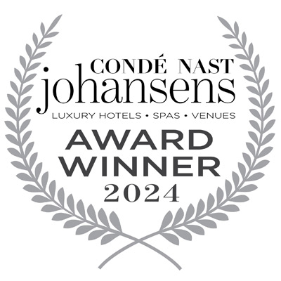 The image shows a "Condé Nast Johansens Award Winner 2024" emblem for luxury hotels, spas, and venues within a laurel wreath design ending the sentence.